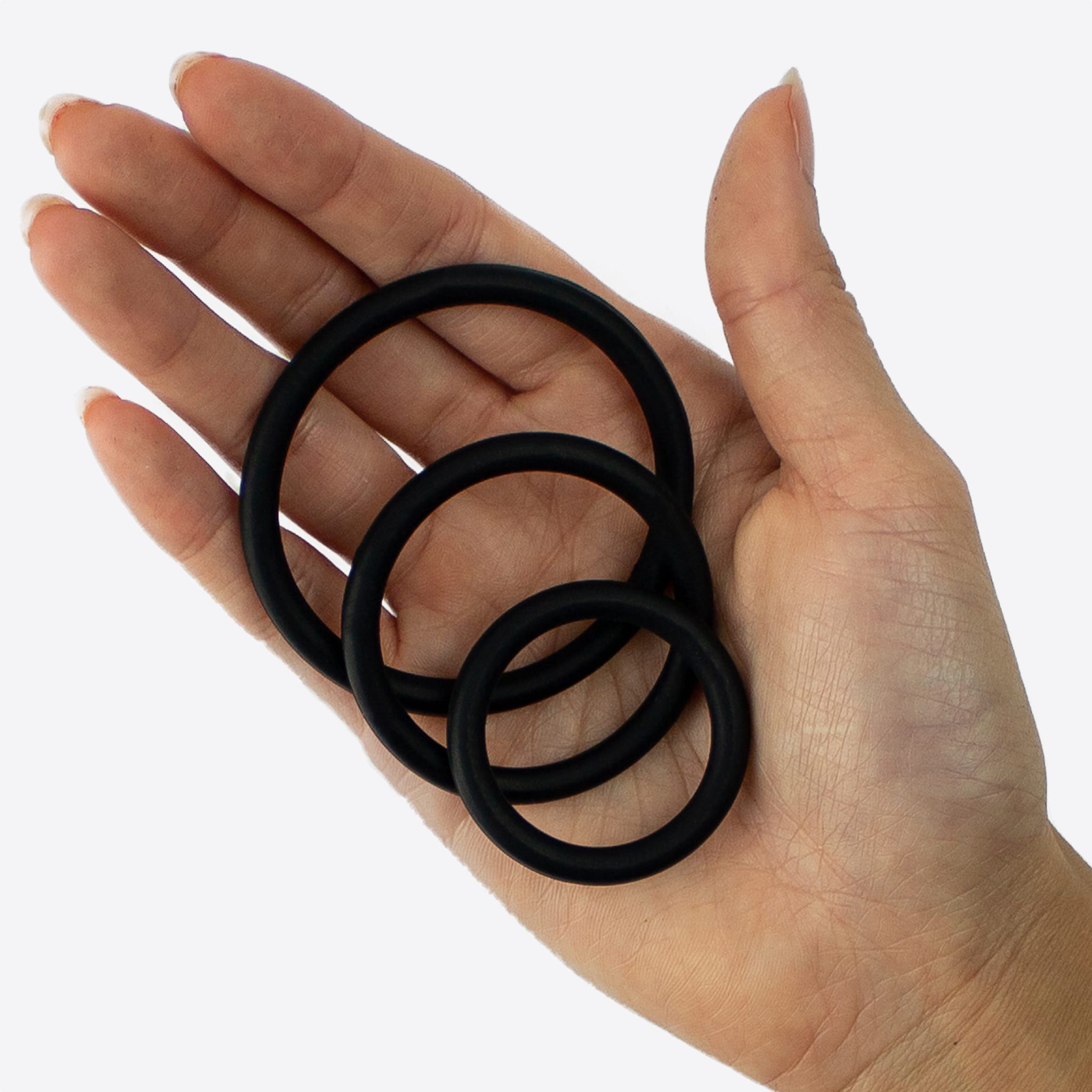 Unilove Basics penisring sæt 3 stk. set oppefra holdt i feminin hånd